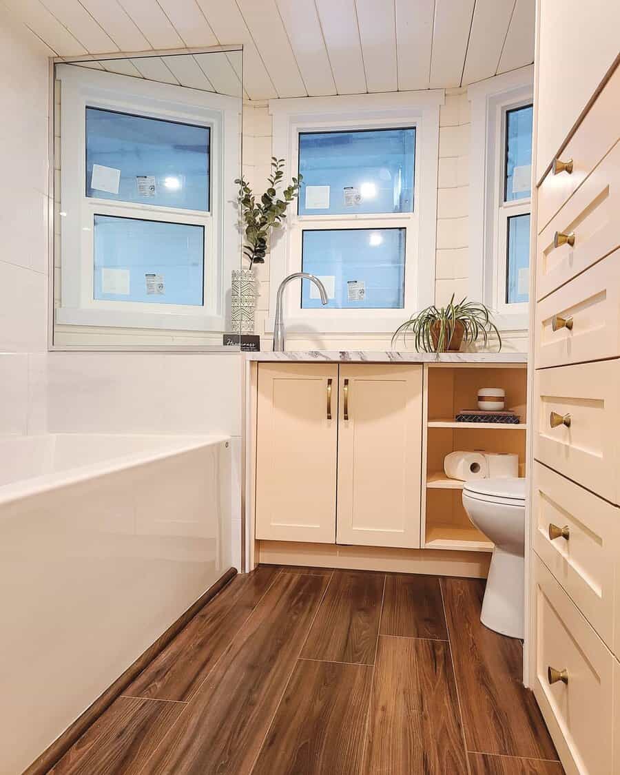 Modern bathroom with wooden floor and white cabinets