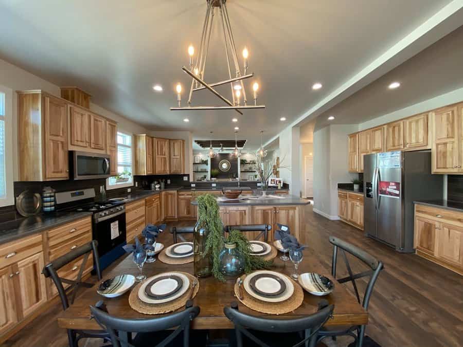 Open kitchen and dining space with wooden cabinets and lighting fixture
