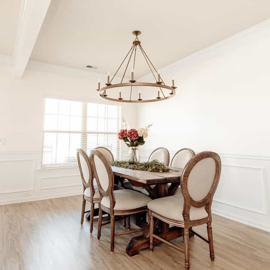 Warm dining room with circular chandelier and wood table