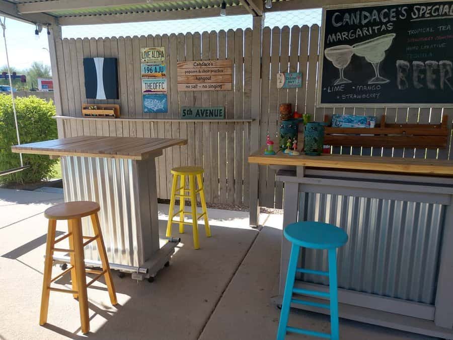 Sunny patio bar with colorful stools and signboards