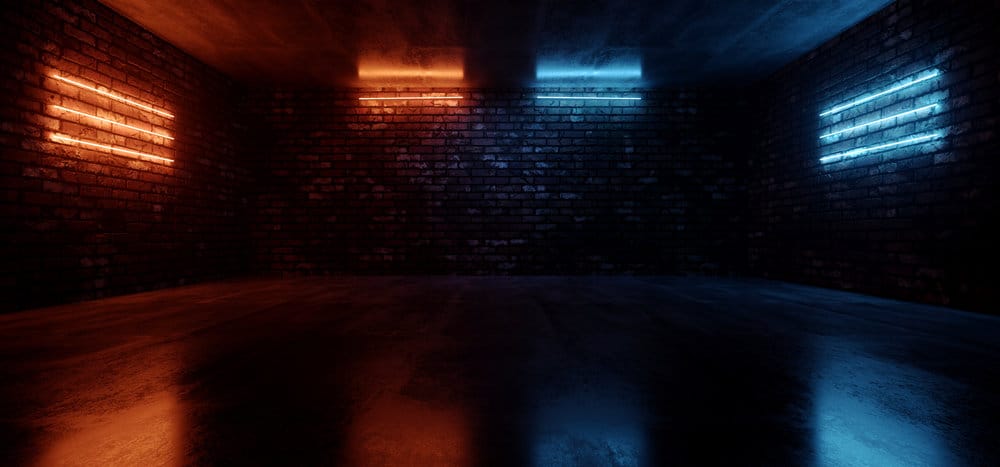Dim room with orange and blue neon lights on brick walls