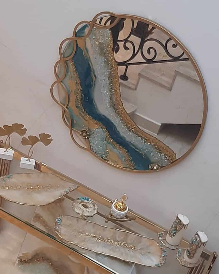 Elegant mirror with gold frame and glass table featuring gold and white details