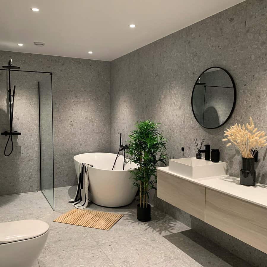 Modern gray bathroom with freestanding tub and greenery