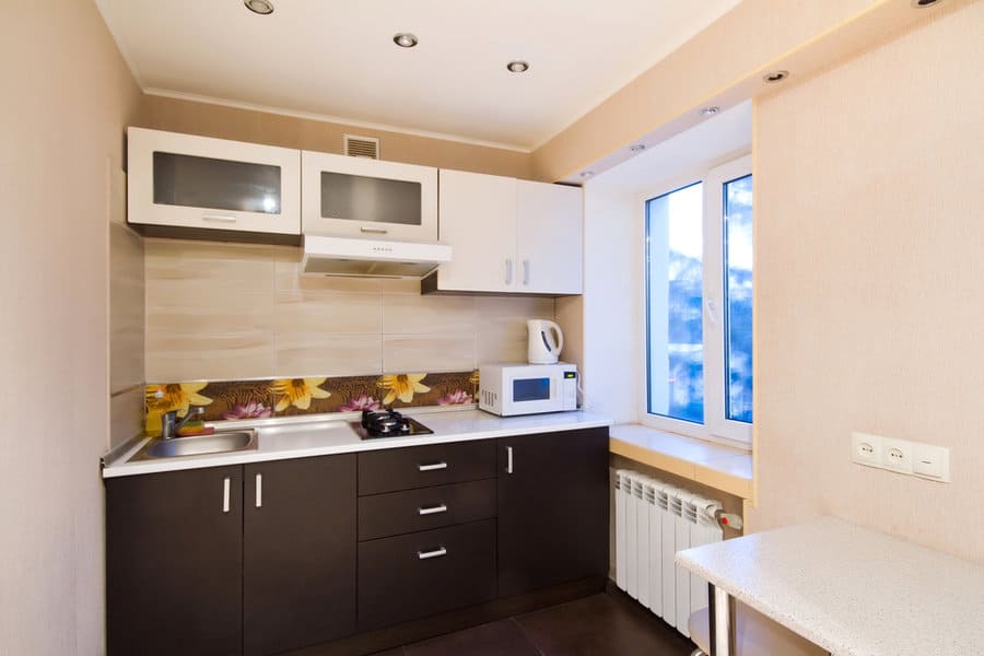 Apartment Tiny Kitchen Ideas 1 Compact kitchen with white cabinets, dark base, and floral backsplash