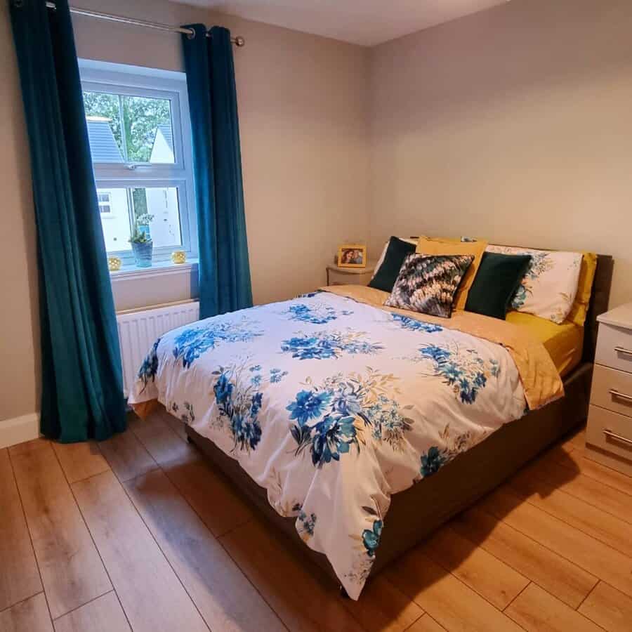Cozy bedroom with blue curtains and floral bedding