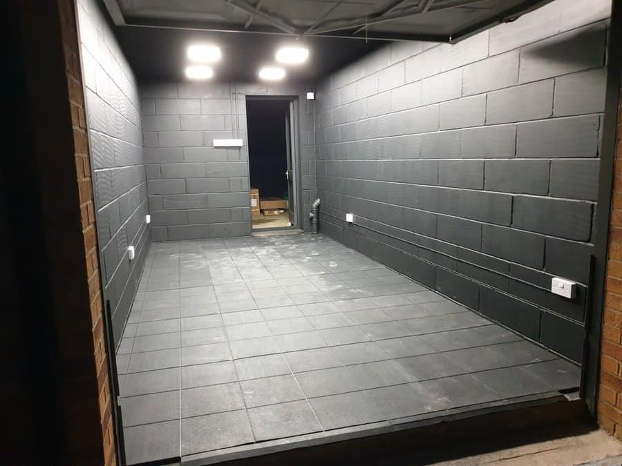 Empty garage with dark tiled walls and floor