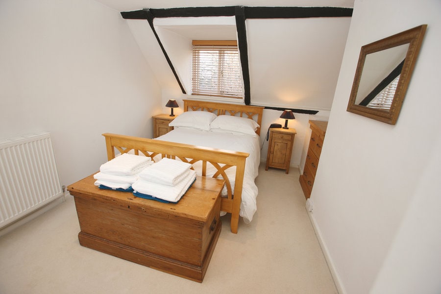 Minimalist attic bedroom with wooden beams and furniture